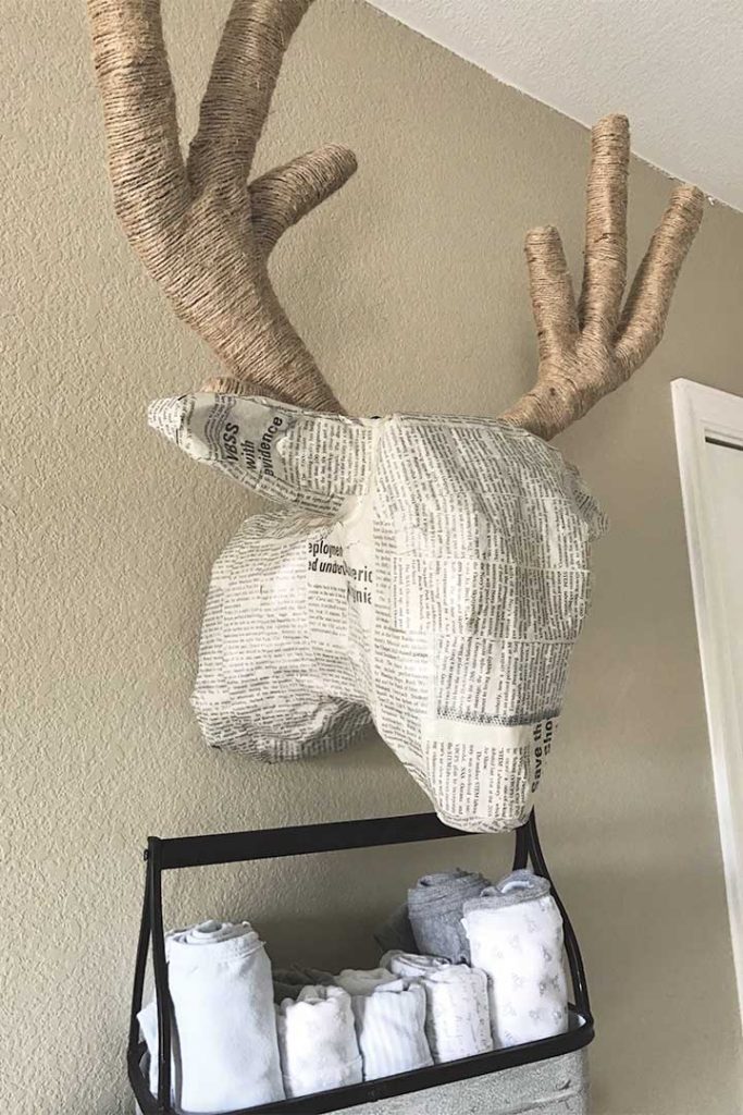DIY paper mache deer head hanging on wall in woodland nursery