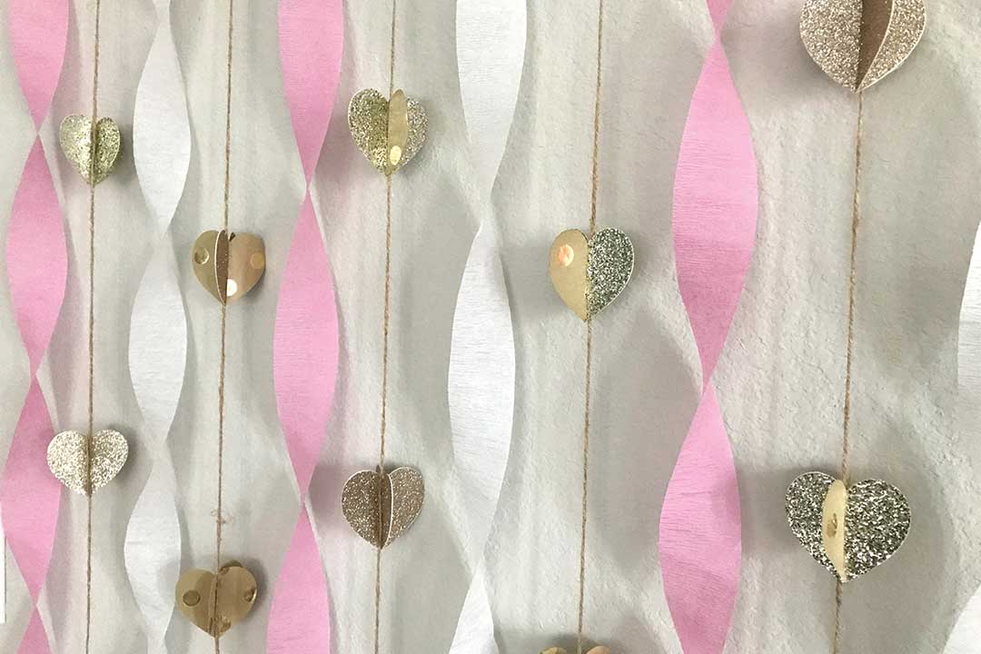 neutral heart garland paired with twirled pink and white paper streamers
