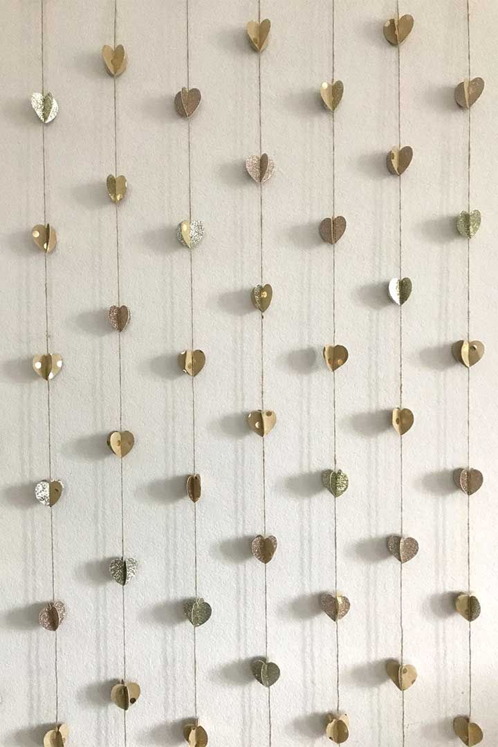 neutral paper and twine heart garland hanging on wall  