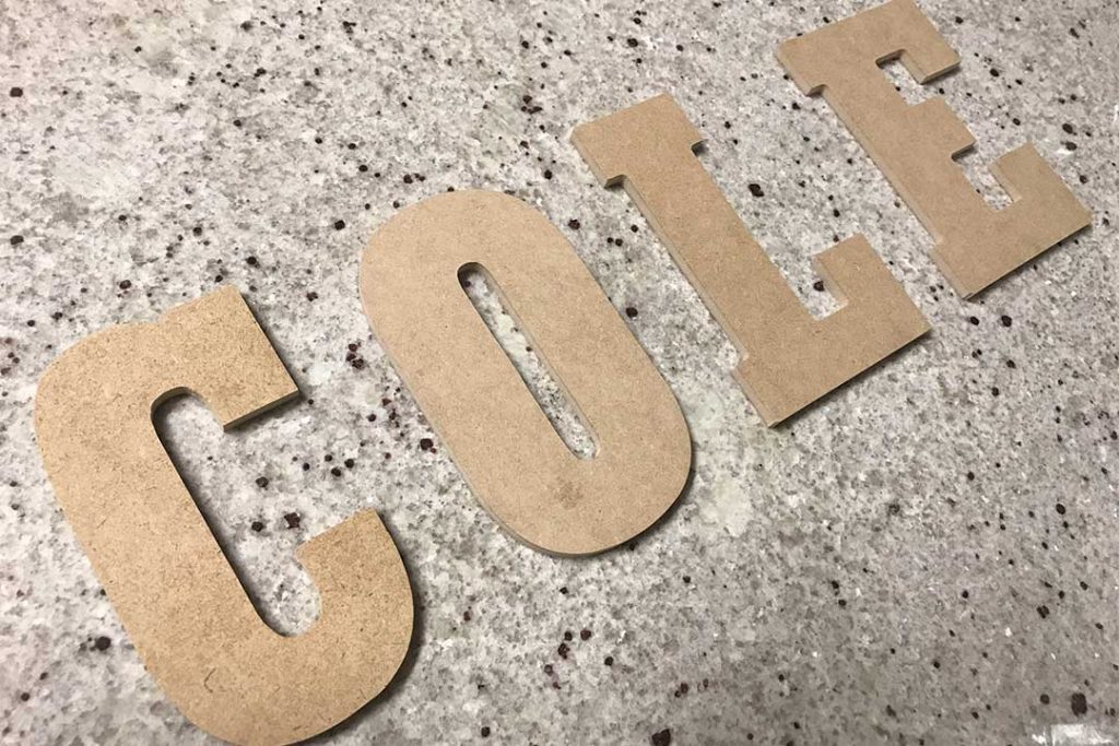 bare wood letters laying on a granite counter