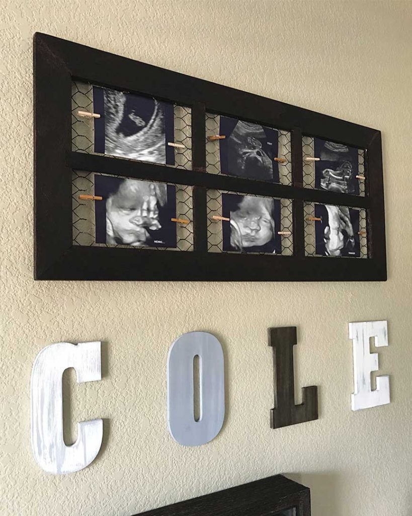 diy painted wood letters hanging on nursery wall with a diy ultrasound picture frame above