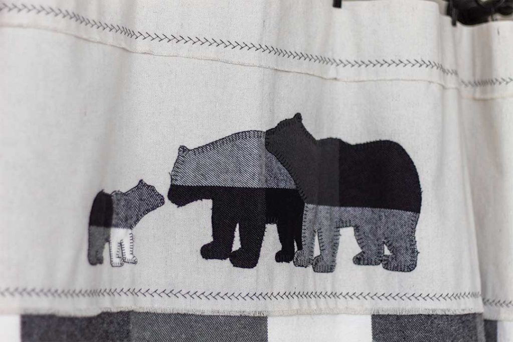 close up of drop cloth curtain header with black bear applique of mama, papa, and baby bear