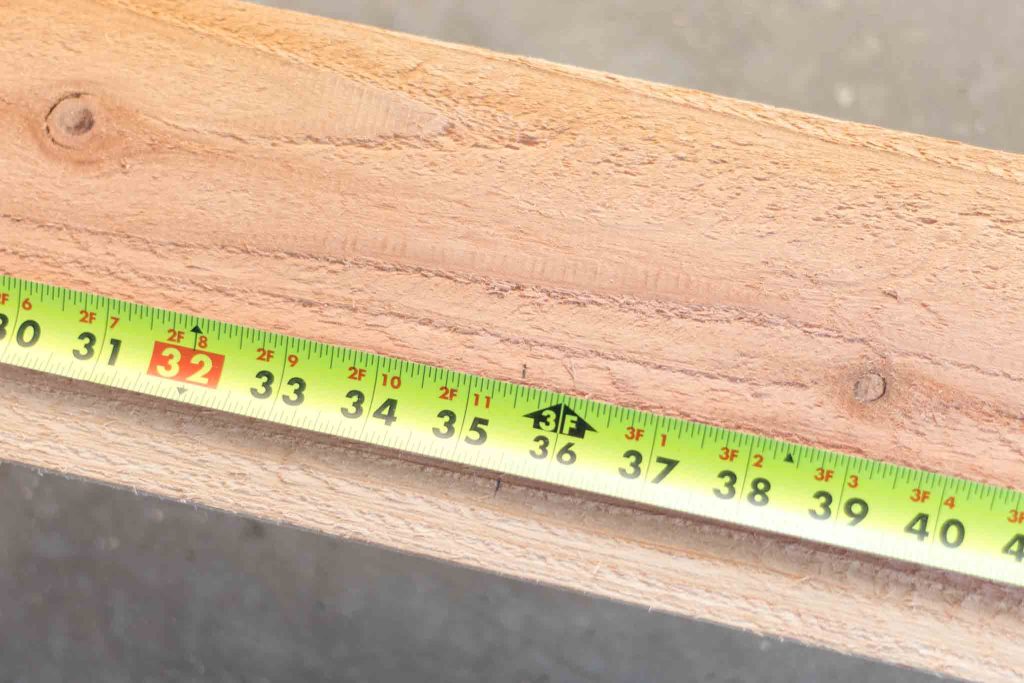 measuring tape on a cedar fence picket to mark cut location at 2 foot 11 and a half inches