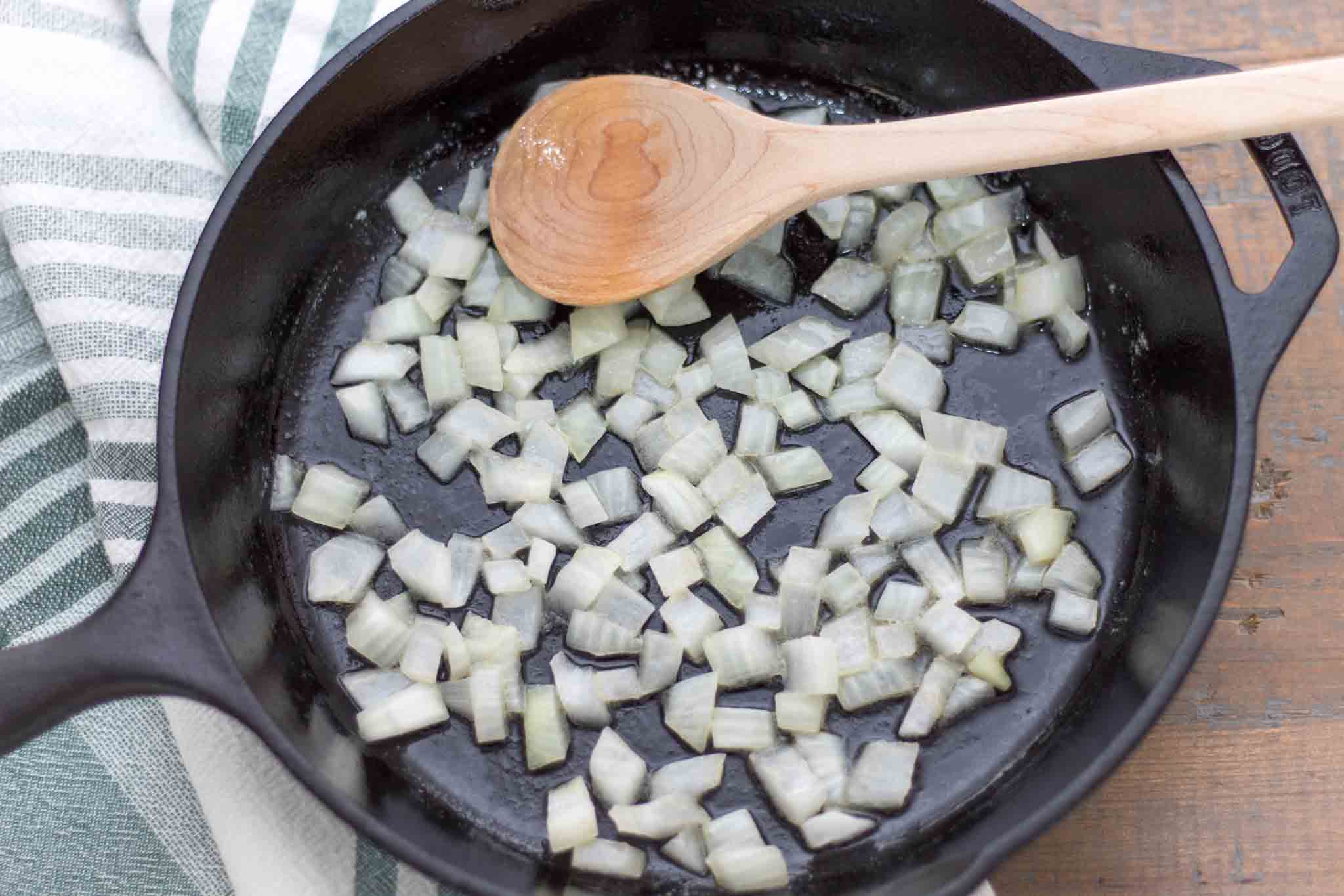 diced white onion sautéed in butter in a cast iron skillet with maple wood spoon