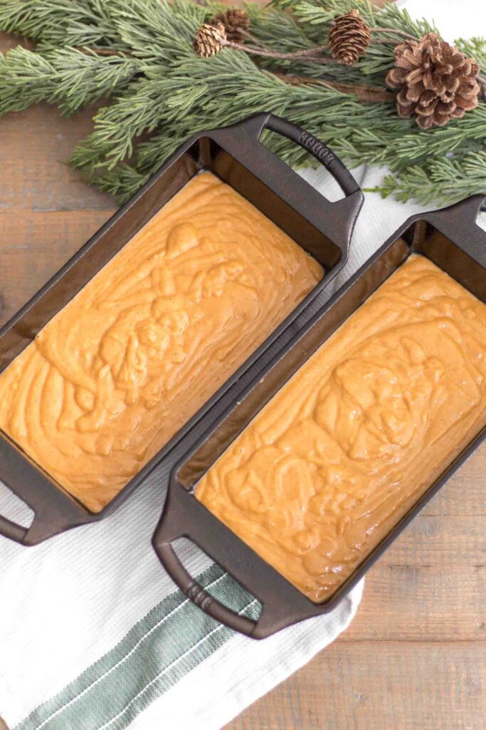 einkorn pumpkin bread batter divided evenly and poured into two cast iron loaf pans