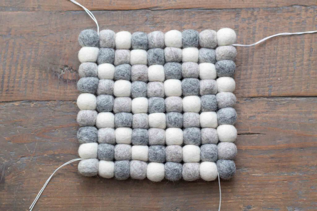 close-up of all nine rows threaded together perpendicularly, pulled taut, and tied off to create a sturdy and even square trivet