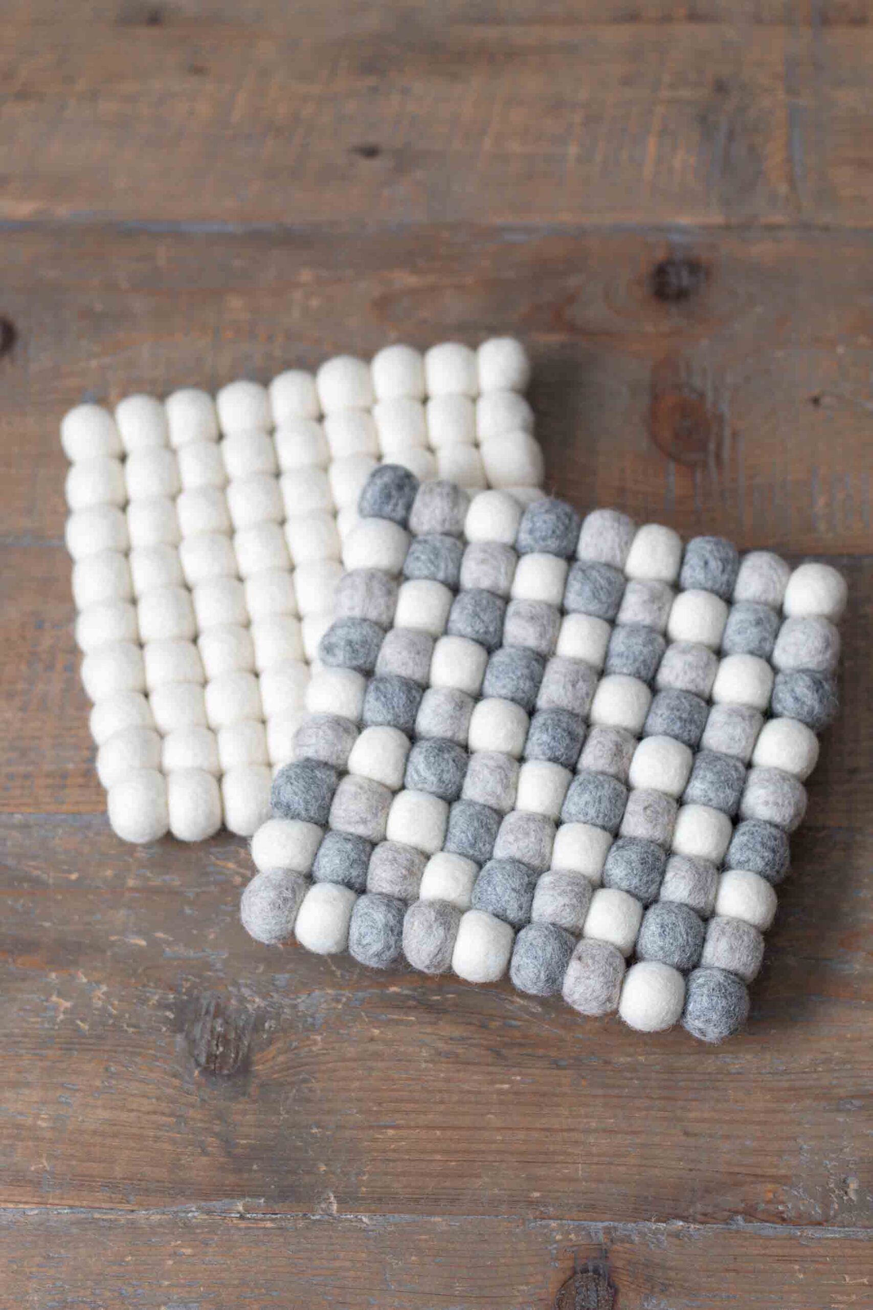 square wool felt ball trivets in natural wool shades of ivory and gray