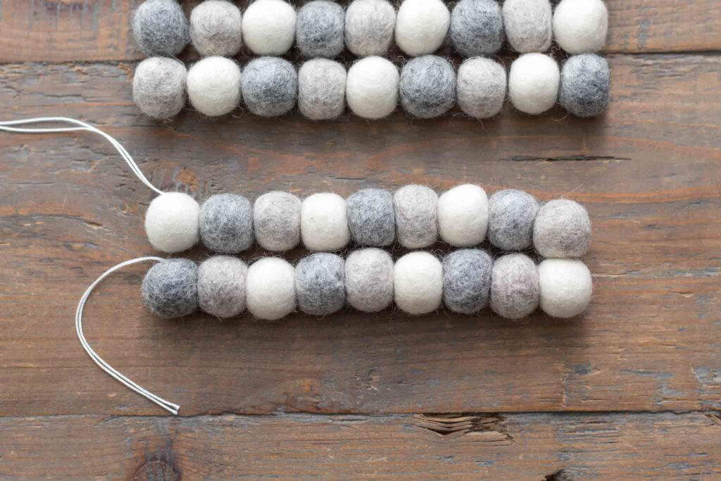 close-up of the first two rows of threaded wool felt balls