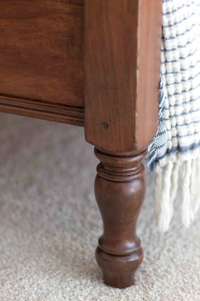 close-up of an antique spindle bed foot refinished in a medium brown stain