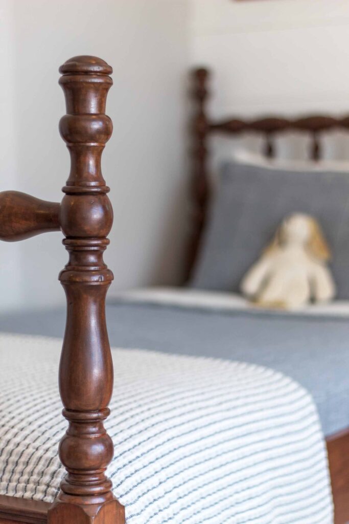 photo of a refinished antique jenny lind spindle bed post with dusty blue and ivory bedding