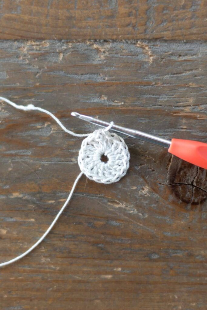magic ring with one round of double crochets in white crochet thread with hook at slip stitch to close the round