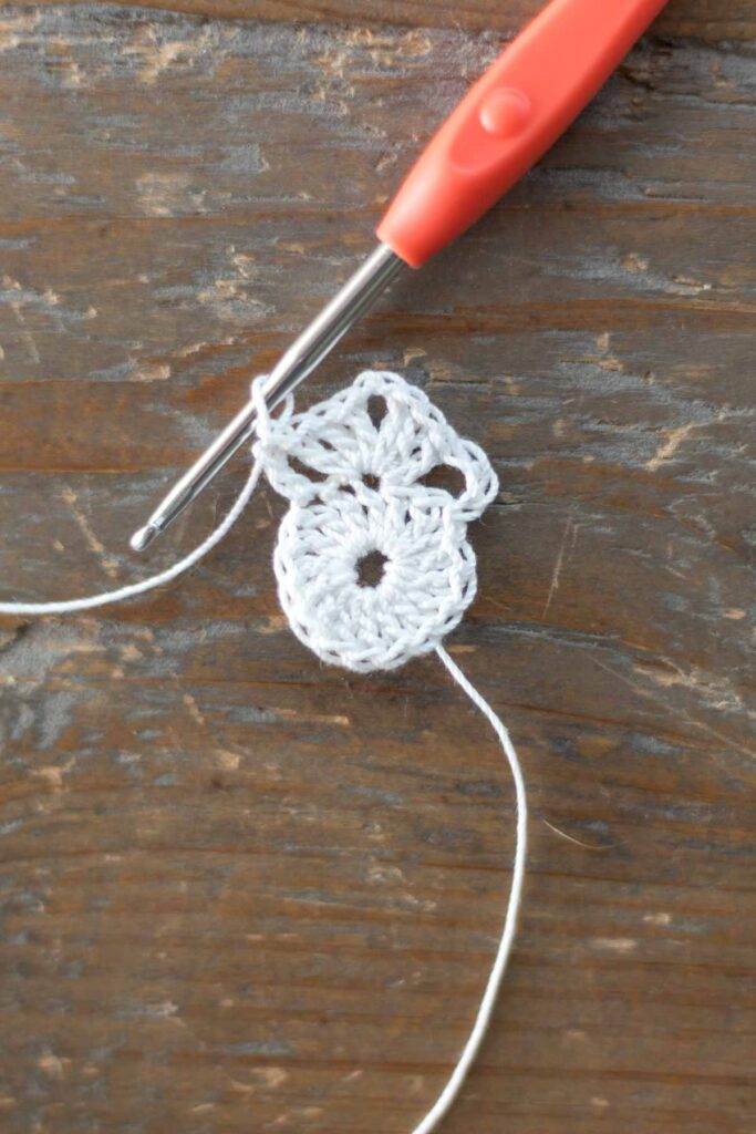 first row of chain 3, 3 double crochets, chain 2, and 4 double crochets at the top of the round beginning the body of the cross bookmark