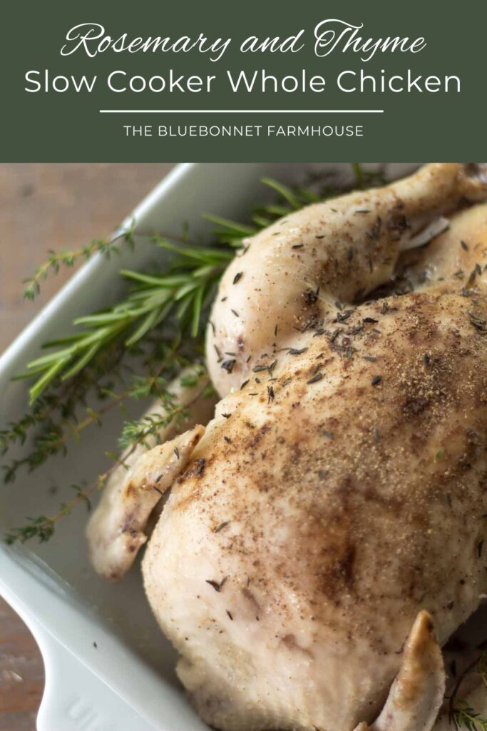 closeup of slow cooker whole chicken covered in salt and pepper lying on a bed of fresh rosemary and thyme in a white baking dish. text reads "rosemary and thyme slow cooker whole chicken -the bluebonnet farmhouse"