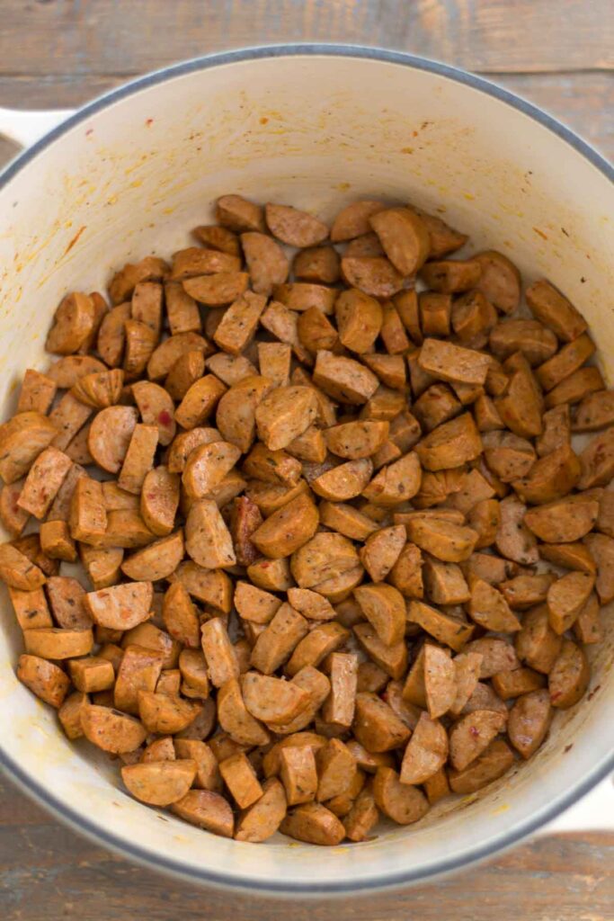 sautéed sausage that has been browned in an enamel cast iron dutch oven