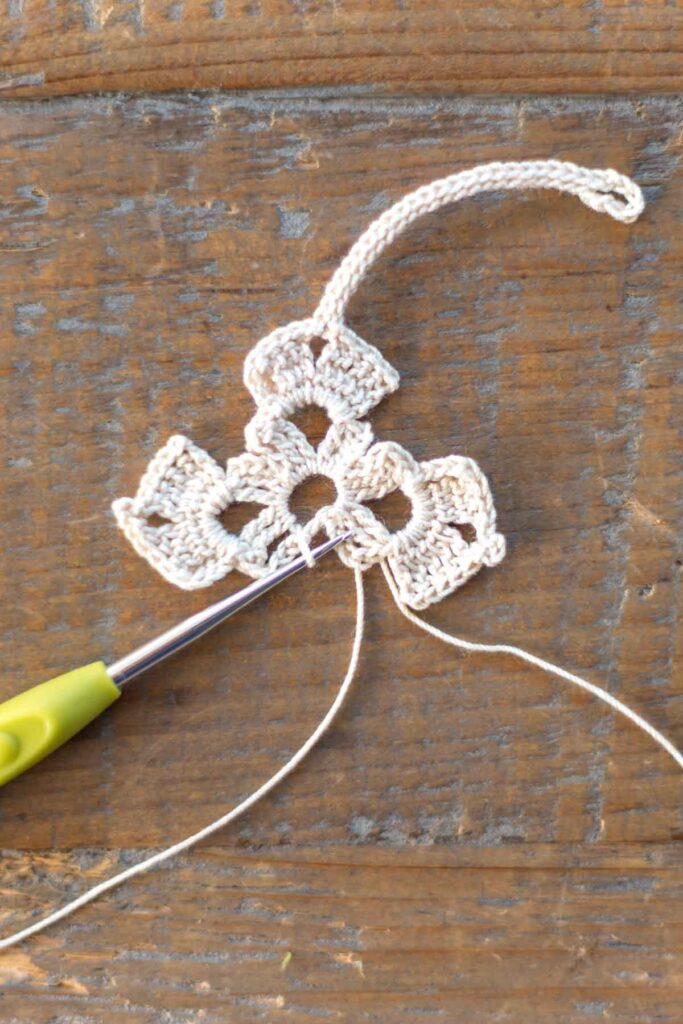 completed left arm of the cross bookmark with two rows of triple crochet stitches, chain stitches, and slip stitches